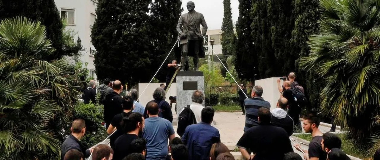 Protestors using ropes to pull down the Harry Truman statue in Athens