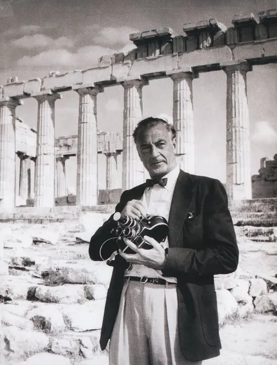 Actor Gary Cooper standing in front of the Parthenon with his film camera on the Acropolis of Athens in 1956