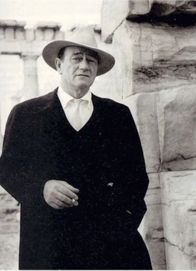 Actor John Wayne standing in front of the Parthenon on the Acropolis of Athens in 1966