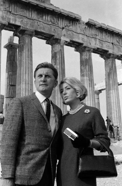 American actor and film maker Kirk Douglas with his wife standing in front of the Parthenon on the Acropolis of Athens in 1964