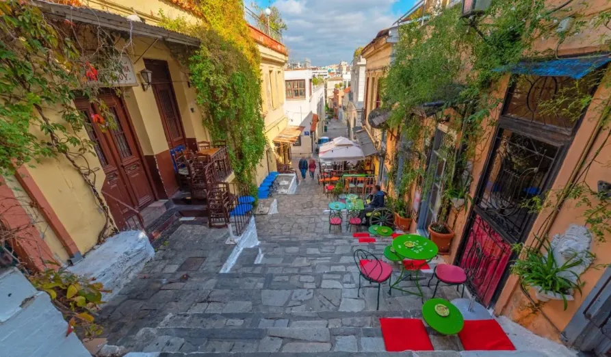 Walking down the Athens neighbourhood of plaka in the daytime seeing cafes and shops