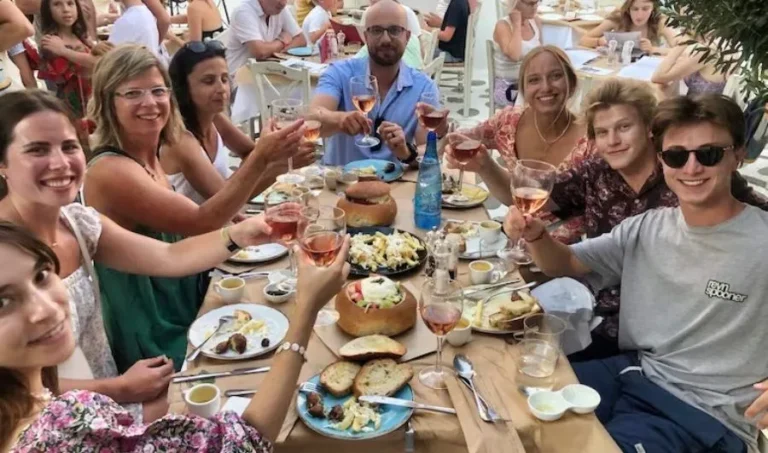 Group of Cheese lover's sat around table eating cheese and wine on the Greek island of Naxos