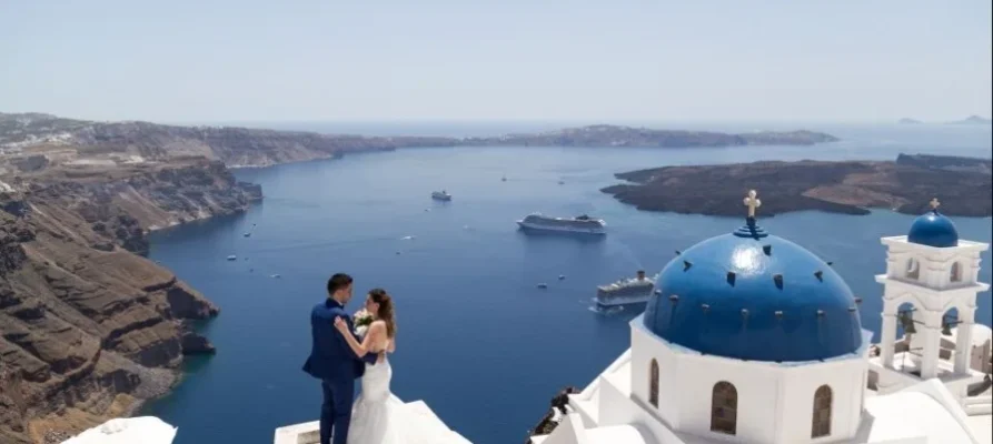 Couple sharing a romantic moment at the Blue Domed Churches, Santorini, Greece. Seen as part of the Private Half-Day Tour in Santorini