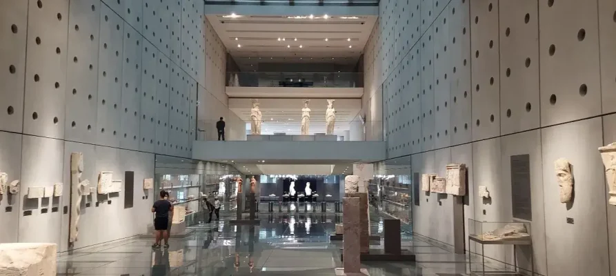 Exhibits including the parthenon caryatids in the hallway Parthenon frieze exhibit at the Acropolis museum in Athens