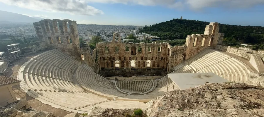 Odeon of Herodes Atticus on the Acropolis of Athens in Greece. In the background is the Filopappous Monument on Filopappous Hill Athens Greece