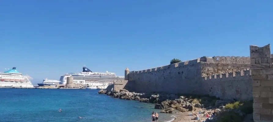 Two cruise ships and a ferry anchored at Mandraki Marina and Port