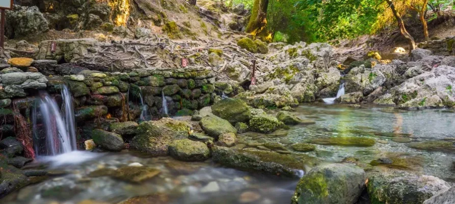 Four very small waterfalls falling over a little rick embankment at the Seven Springs in Rhodes, Greece