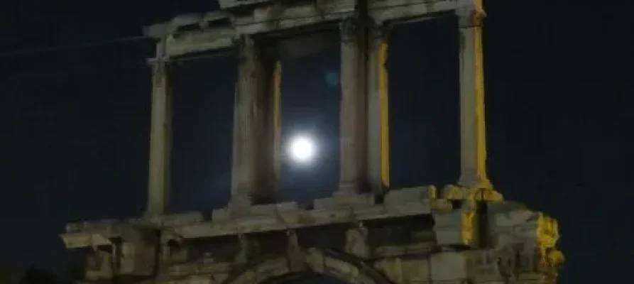 The Arch of Ahdrian at night with the moon looking through the middle