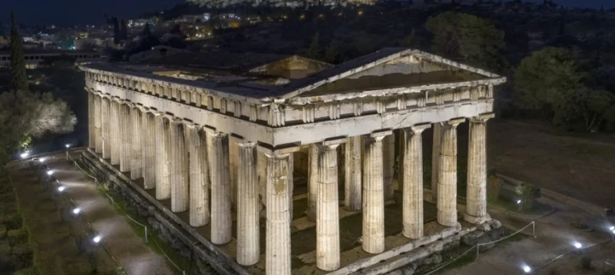 Night time view of the Temple of Hephaestus in the Ancient Agora of Athens with the Acropolis in the background