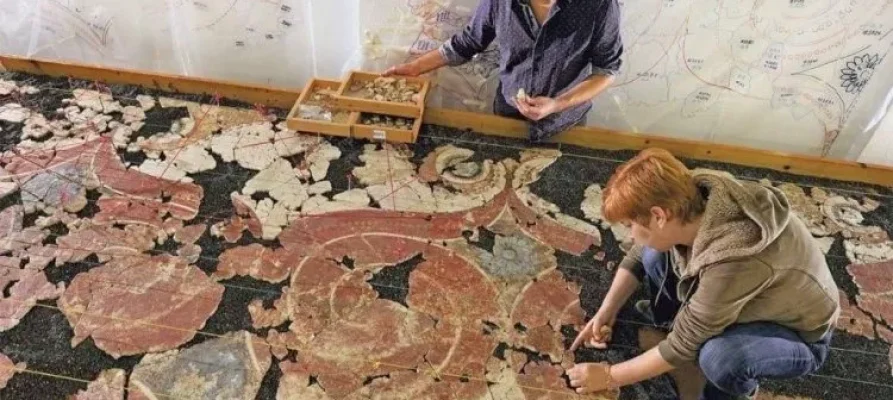 Two women assembling an ancient floor mosaic at Akrotiri on Santorini. Seen as part of the Santorini: Akrotiri Prehistoric City Private Guided Tour